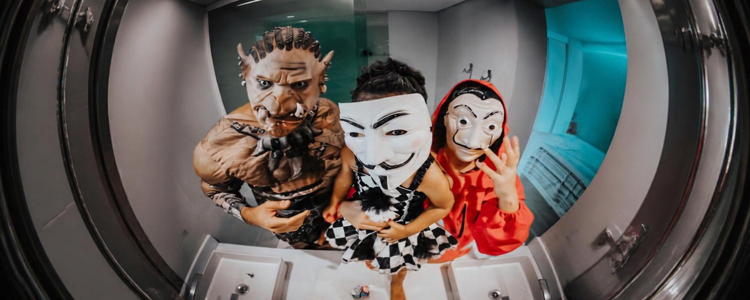 Trois personnes déguisées avec des masques lors d’une soirée costumée