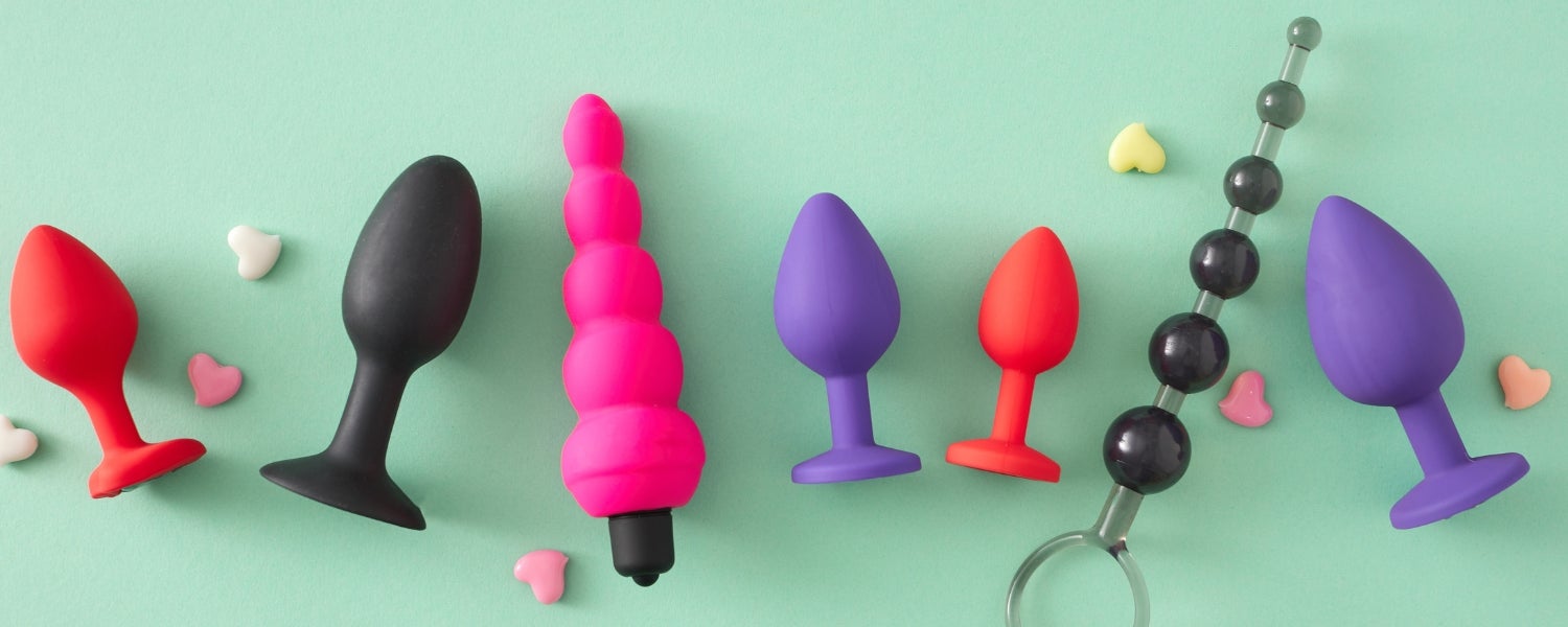 Divers jouets anaux colorés sur un fond vert pastel.