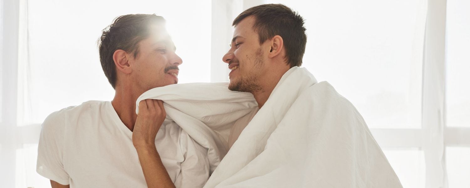 Schwules Paar beim Kuscheln im Bett – intime Momente und Nähe zwischen Männern