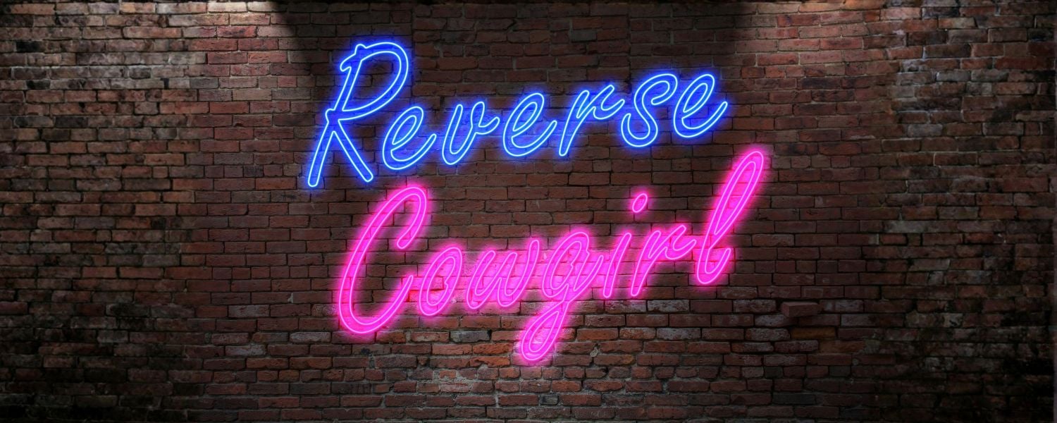 L'inscription « Reverse Cowgirl » en néon sur un mur de briques