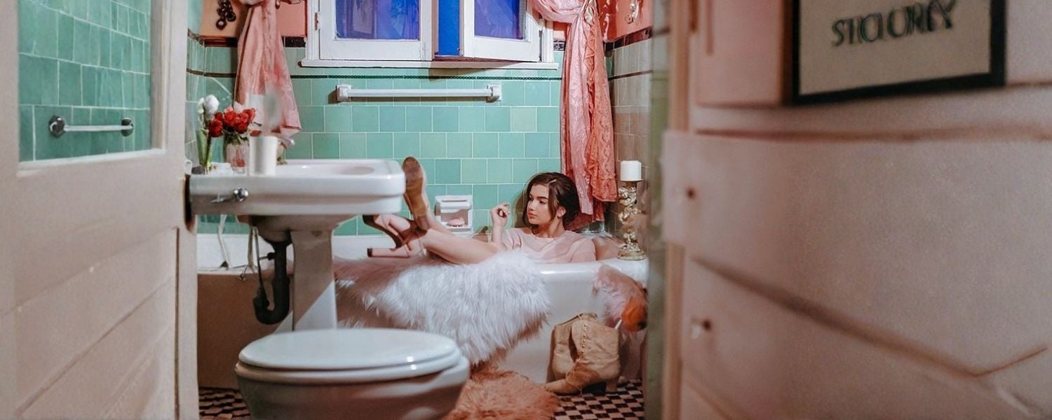 Frau in Badewanne mit Lippenstift und Tattoos