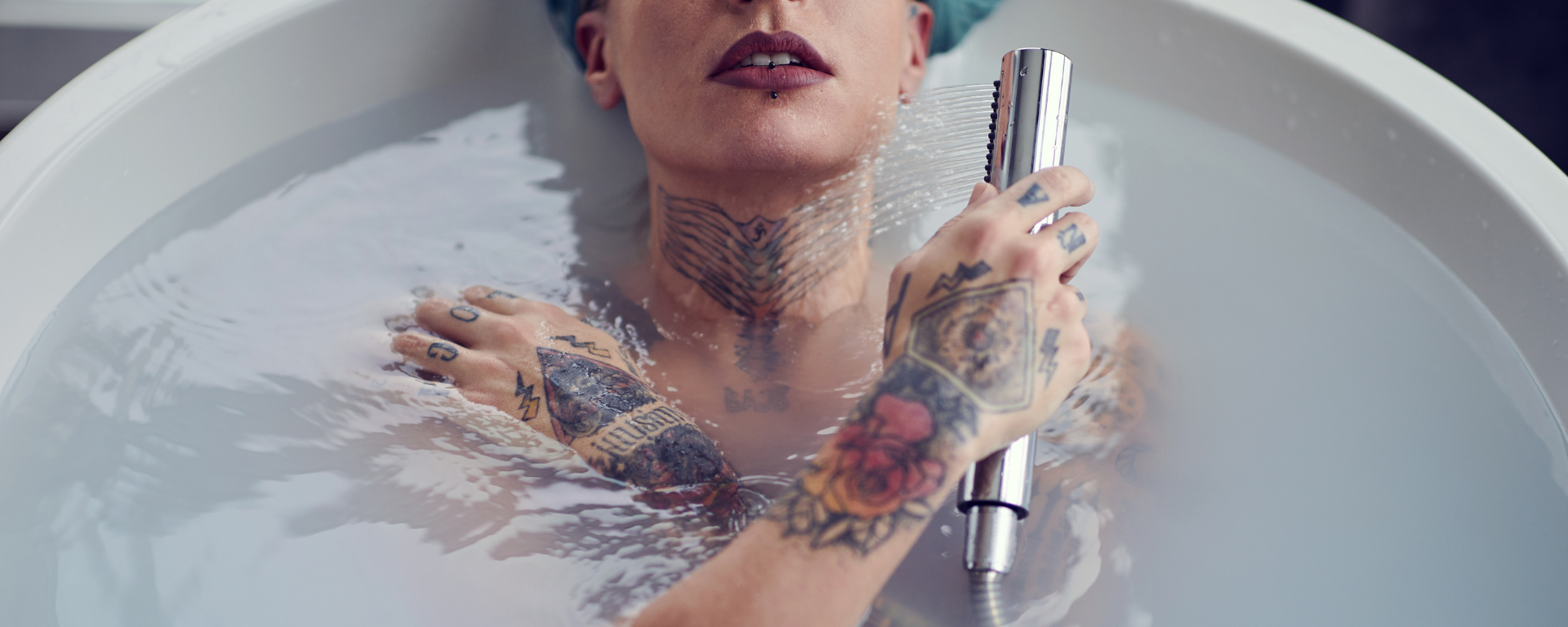Frau in Badewanne mit Lippenstift und Tattoos