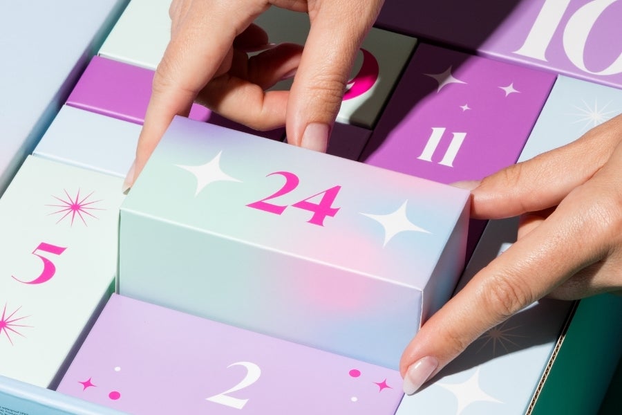 Calendrier de l'Avent Amorana Discover 2026 : découvre chaque jour une nouvelle surprise Des mains ouvrent une petite porte du calendrier de l'Avent Amorana Discover 2026, qui réserve 24 surprises quotidiennes