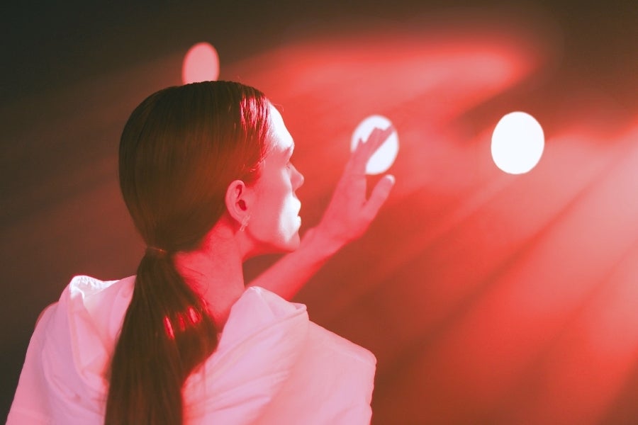 Erotische Fantasien und Intimität: Die Bedeutung von Neugier und Vorstellungskraft Person in roter Lichtstimmung, symbolische Darstellung von Fantasie, Intimität und erotischer Spannung