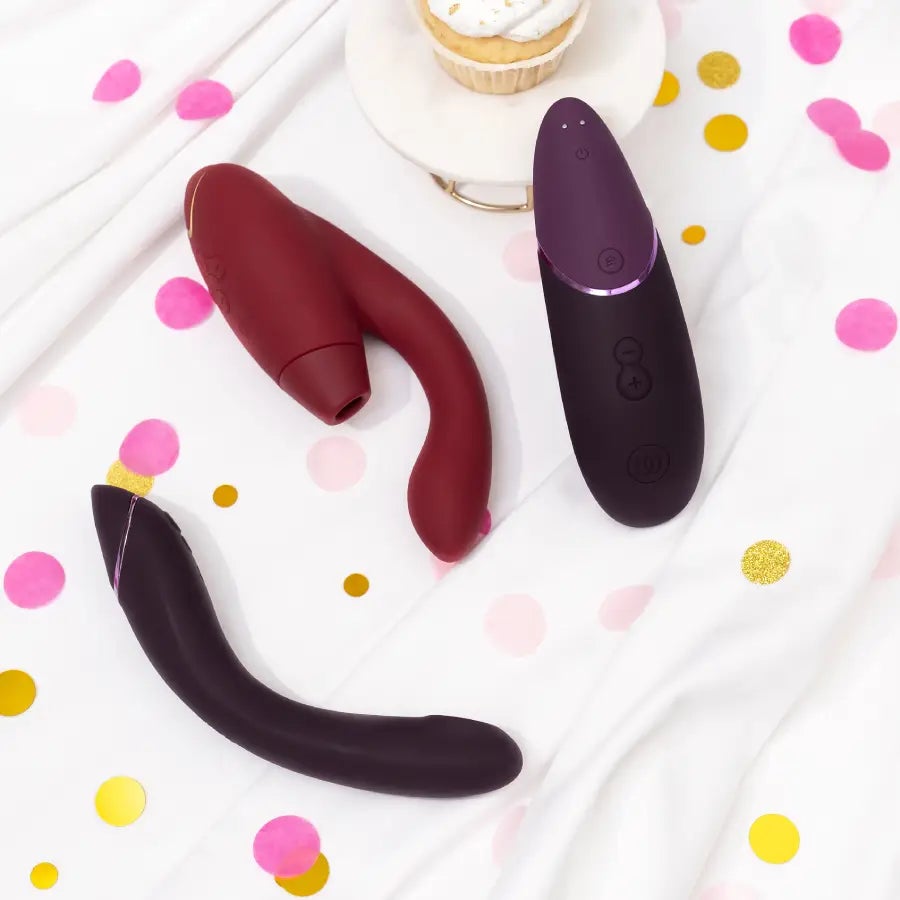 Eine Frau in schwarzer Unterw&auml;sche auf einem wei&szlig;en Bettlaken, die einen rosa Vibrator h&auml;lt