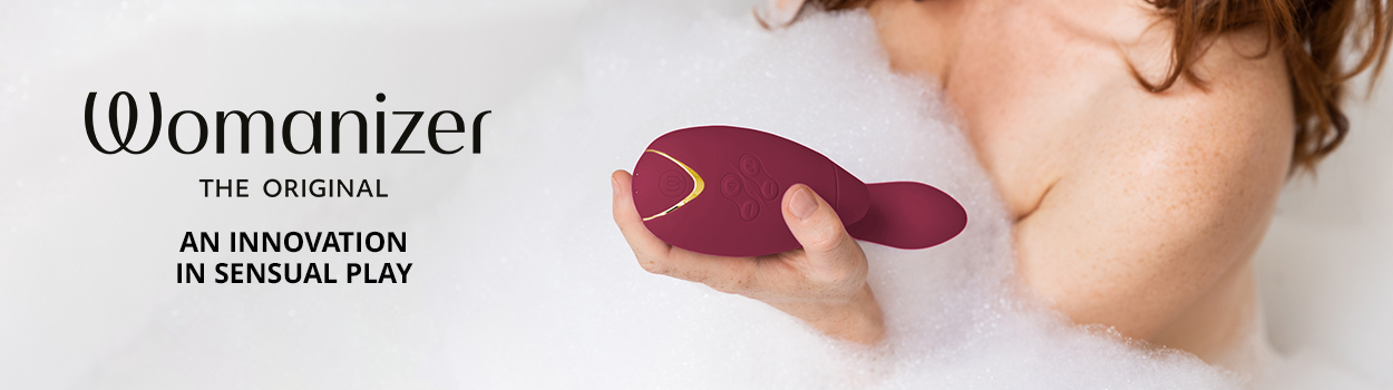 A woman in a bathtub holding a red Womanizer Duo 2. Text: "Womanizer The Original An innovation in sensual play"