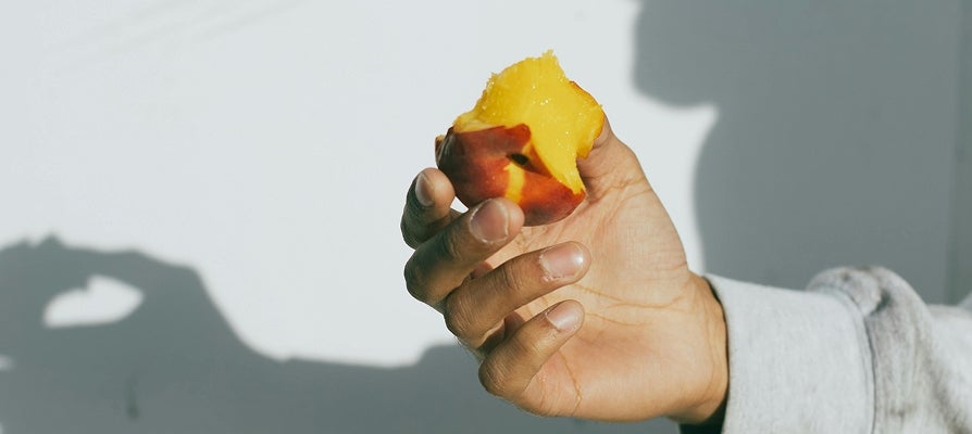 Person eating a peach